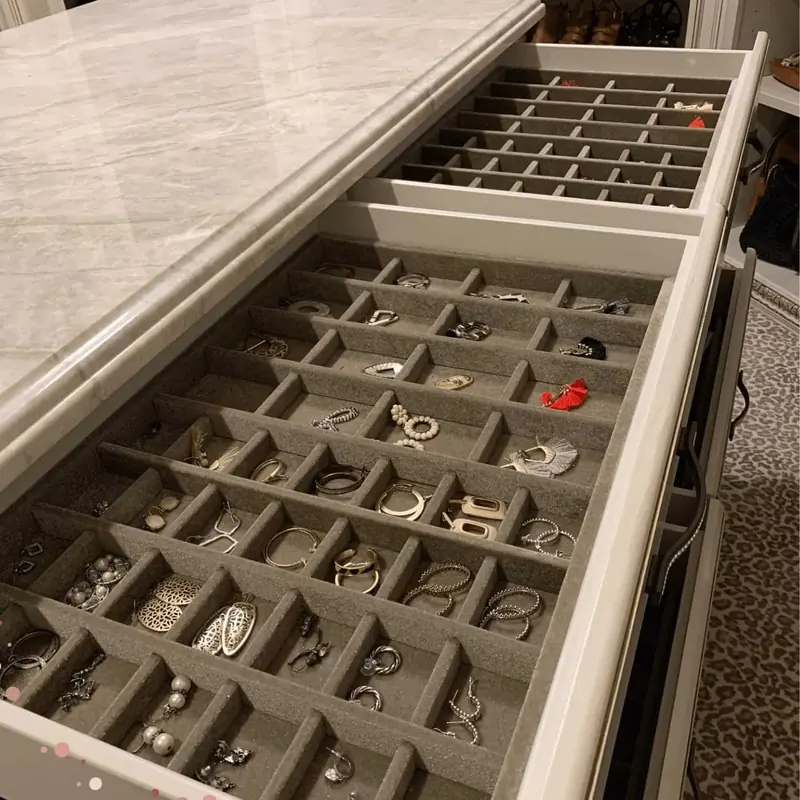 Gray velvet drawer insert filled with earrings and jewelry